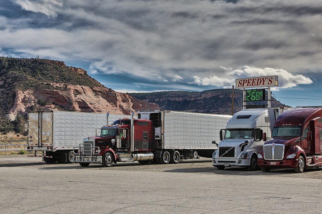 Illustrative photograph of semi Truck and Trailers at a Gas Station Entering the Mountains of New Mexico